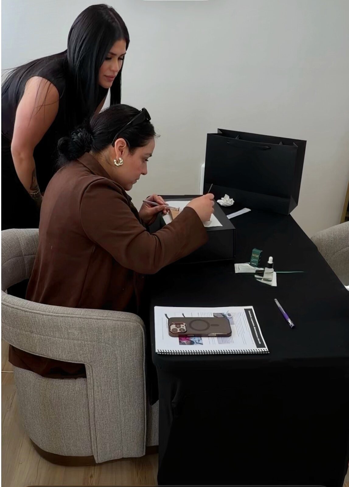 Kenia guiding a student at the practice table